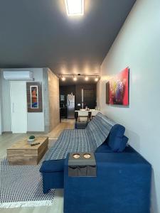 uma sala de estar com um sofá azul num quarto em Loft Praia Brava - Itajaí Camboriú piscina e playground em Itajaí