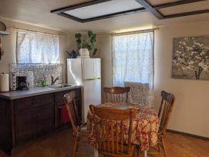 cocina con mesa y nevera blanca en Rustic Rooms Barn Loft (Upstairs Studio Apartment) Near Kings Canyon & Sequoia National Parks, en Squaw Valley