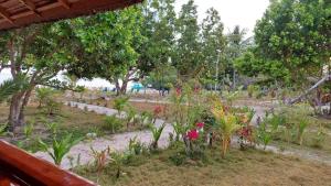 a garden with flowers and trees in a park at La Tranquilidad Beach Club 