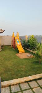 a playground with a yellow slide in a yard at Pk Guest house in Mysore