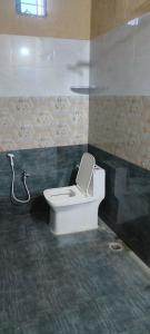 La salle de bains est pourvue d'une douche et de toilettes. dans l'établissement Pk Guest house, à Mysore