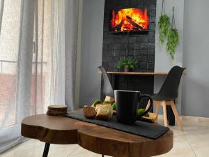 a living room with a fireplace and a coffee table at R&K MODERN APARTMENT in Xanthi