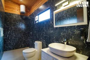 y baño con lavabo, aseo y espejo. en StayVista at Secret Solace en Dehradun