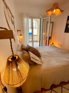 - une chambre avec un lit doté d'une lampe et d'un miroir dans l'établissement Can Somni - Appartement bohème, zen et chic avec piscine, à Cala Figuera