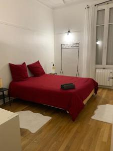 a bedroom with a large red bed with red pillows at MARTROI Cœur de Ville in Orléans
