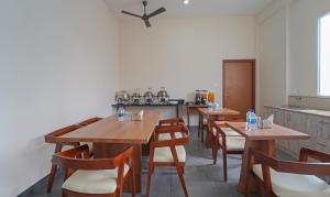 a restaurant with wooden tables and chairs and a kitchen at Itsy By Treebo - Avani Stays - Vyttila, Kochi in Ernakulam