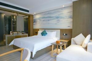 a hotel room with a bed and a couch at Paco Hotel Tiyuxilu Metro Guangzhou- 1 minute walk from the subway in Guangzhou