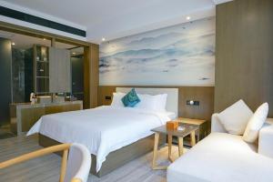 a hotel room with a bed and a couch at Paco Hotel Tiyuxilu Metro Guangzhou-Close to subway entrance in Guangzhou