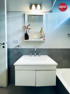 a bathroom with a white sink and a mirror at Rent Aguero in Buenos Aires