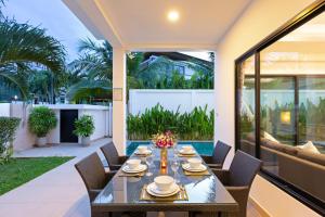 - une table à manger sur la terrasse d'une maison dans l'établissement Villa White Pool, à Kamala Beach
