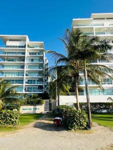 duży budynek z palmami przed plażą w obiekcie Morros Vitri California w mieście Cartagena de Indias
