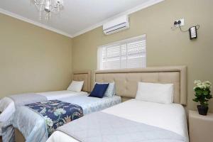 - une chambre avec 2 lits et une fenêtre dans l'établissement Camdene Guesthouse, au Cap