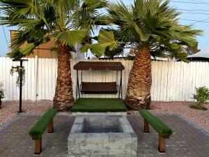 a courtyard with two palm trees and a fountain at Fully Remodeled, Landscaped, King Beds, Desk Space in Las Vegas