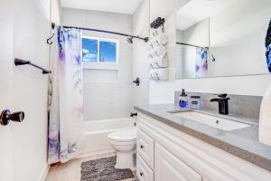 a white bathroom with a sink and a toilet at Fully Remodeled, Landscaped, King Beds, Desk Space in Las Vegas