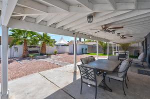 an outdoor patio with a table and chairs under awning at Fully Remodeled, Landscaped, King Beds, Desk Space in Las Vegas