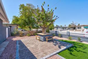 a bench sitting next to a tree in a yard at Fully Remodeled, Landscaped, King Beds, Desk Space in Las Vegas