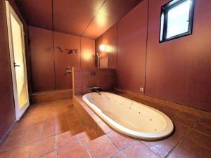 eine große Badewanne im Bad mit Fenster in der Unterkunft SKY Bay-Terace Omura in Omura