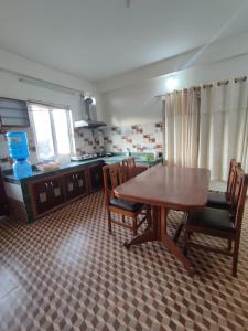 uma cozinha com uma mesa de madeira e cadeiras em Fewa Apartment em Pokhara