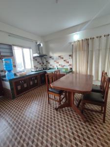 a kitchen with a wooden table and chairs in it at Fewa Apartment in Pokhara +12 photos