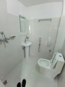 uma casa de banho branca com um WC e um lavatório em Fewa Apartment em Pokhara