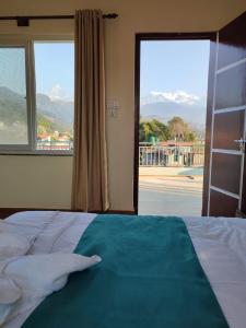 um quarto com uma cama e uma grande janela em Fewa Apartment em Pokhara