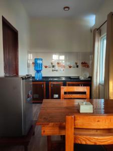 uma cozinha com uma mesa de madeira e um frigorífico em Fewa Apartment em Pokhara