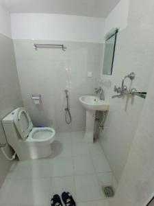 uma casa de banho branca com um WC e um lavatório em Fewa Apartment em Pokhara
