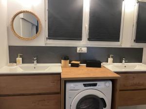 eine Waschküche mit 2 Waschbecken und einer Waschmaschine in der Unterkunft Appartement place de Cambrai in Cambrai