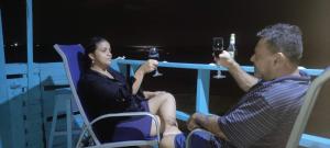 a man and woman sitting in chairs drinking wine at Hotel Victoria s Beach House in Roatán