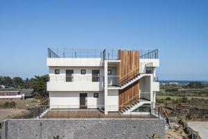 a house with a staircase on the side of it at Handongijen Pension in Jeju