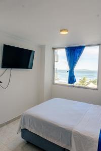 a bedroom with a bed with a window and a flat screen tv at Acogedor Apartaestudio Laguito 1 Habitacion N4A in Cartagena de Indias