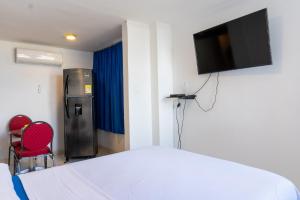 a bedroom with a bed and a television on a wall at Acogedor Apartaestudio Laguito 1 Habitacion N4A in Cartagena de Indias