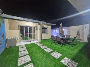 a yard with green grass and a table and chairs at Marques Beach House in Marechal Deodoro