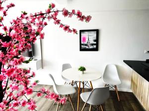 une salle à manger avec une table et un arbre avec des fleurs roses dans l'établissement Bertiz Cozy Jacuzzi, à Guatemala