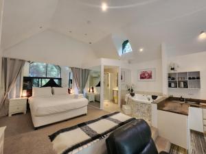 a large bedroom with a bed and a bathroom at Gallery Walk Chalets - Tamborine Mountain in Mount Tamborine