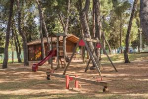 a park with a playground with slides and trees at Rooms Savudrija Plava Laguna in Savudrija