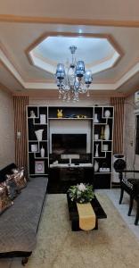 a living room with a fireplace and a chandelier at M & D Rentals by Jick in Butuan