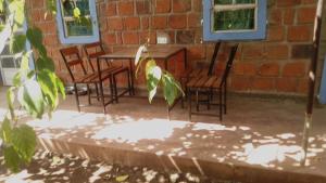 eine Terrasse mit Stühlen, einem Tisch und einem Backsteingebäude in der Unterkunft Kimashuku permaculture garden in Weru Weru