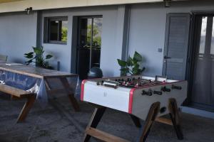 una mesa de juegos y una estufa frente a una casa en Au Coeur des hauts Cilaos en Cilaos