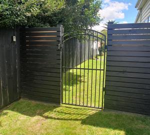 an iron gate in a fence with a yard at Private Cabin in Waihi