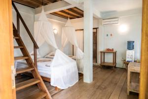 ein Schlafzimmer mit einem Bett mit Deckennetzen in der Unterkunft Casa Nemo Beach Resort & Spa in Sabang
