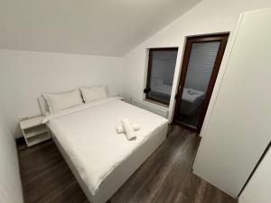 una camera da letto con un letto bianco con un asciugamano sopra di Cabana LUCDAR Valiug Crivaia a Văliug