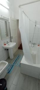 a bathroom with a tub and a sink and a toilet at Cozzy 24 in Maputo +8 photos