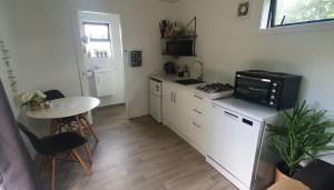 a small kitchen with a stove and a microwave at Private Cabin in Waihi