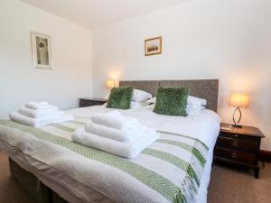 um quarto com uma cama com toalhas em Green Hills Farm em Greenodd