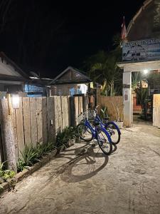 deux vélos garés à côté d'une clôture la nuit dans l'établissement James Bungalow, à Gili Trawangan