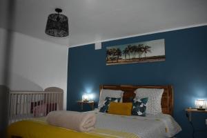 a bedroom with a bed with blue walls at Au Coeur des hauts Cilaos in Cilaos