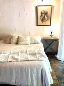 a bedroom with a white bed with a picture on the wall at Heavenly Hacienda in Myocum