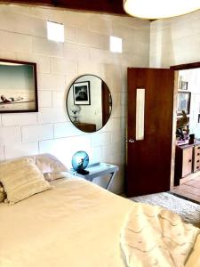 a bedroom with a large bed and a mirror at Heavenly Hacienda in Myocum