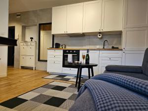 a kitchen with white cabinets and a table with a bottle of wine at URBAN APARTMENTS PREMIUM No 2, FREE private parking, Self CHECK-IN in Chorzów
